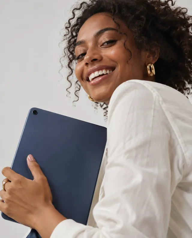 Mulher sorrindo segurando um tablet